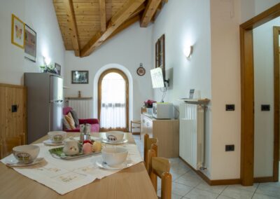 Zona pranzo del Presanella con tavolo apparecchiato e finestra ad arco