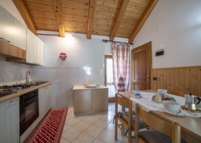 Cucina del Presanella vista dalla zona pranzo, con travi a vista