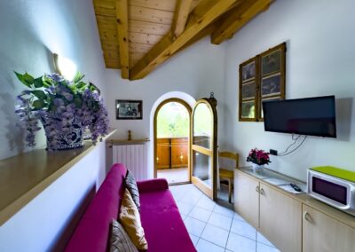 Angolo divano del Presanella con televisore e finestra ad arco