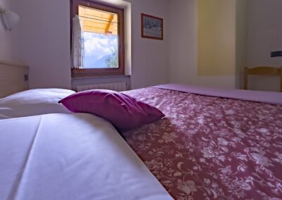 Letto matrimoniale del Presanella con finestra e soffitto in legno