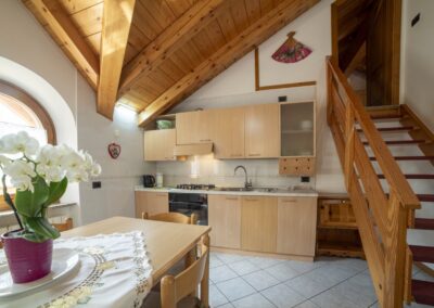 Cucina del Vioz con tavolo apparecchiato e travi a vista