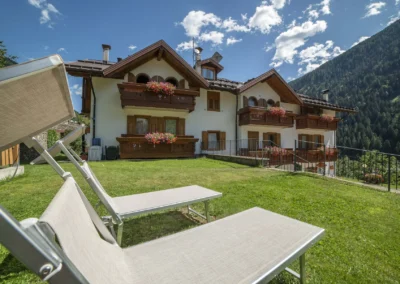 Esterno di Casa Bamby con lettini sul prato e montagne sullo sfondo